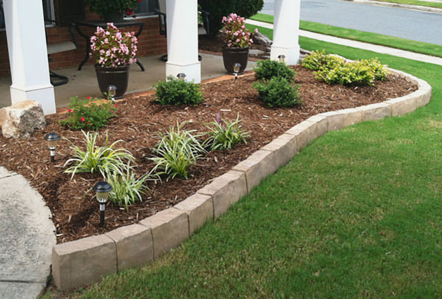 Image of hardscape 12in edgers installed to flow around a freshly planted bed.