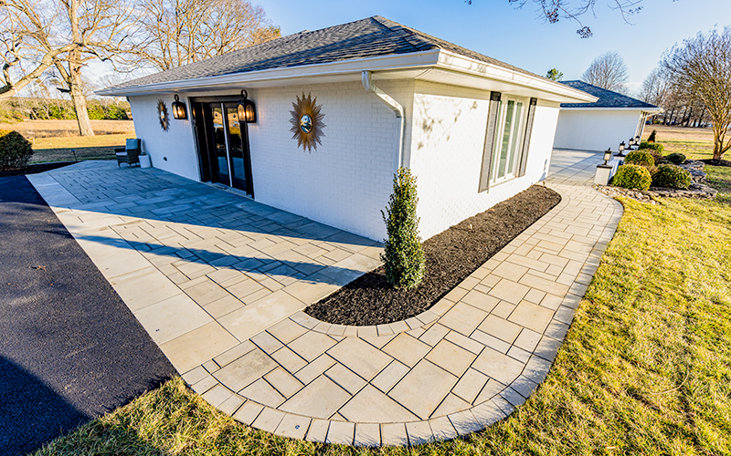 Image of a driveway/patio installation that circles the house using a random pattern.